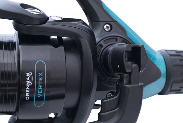 Drennan Vertex 4000 feeder reel body close-up showing the Vertex badge and the one-touch folding handle latch