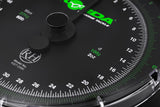 Macro of the dial centre showing the twin needles, the Reuben Heaton RH roundel and the 100g / 2oz graduation marking