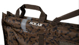 Close-up of the top bar: white SOLAR branding, a grey reflective bar marker, the reinforced webbing carry handle and the weigh strap, plus mesh at the lower right.