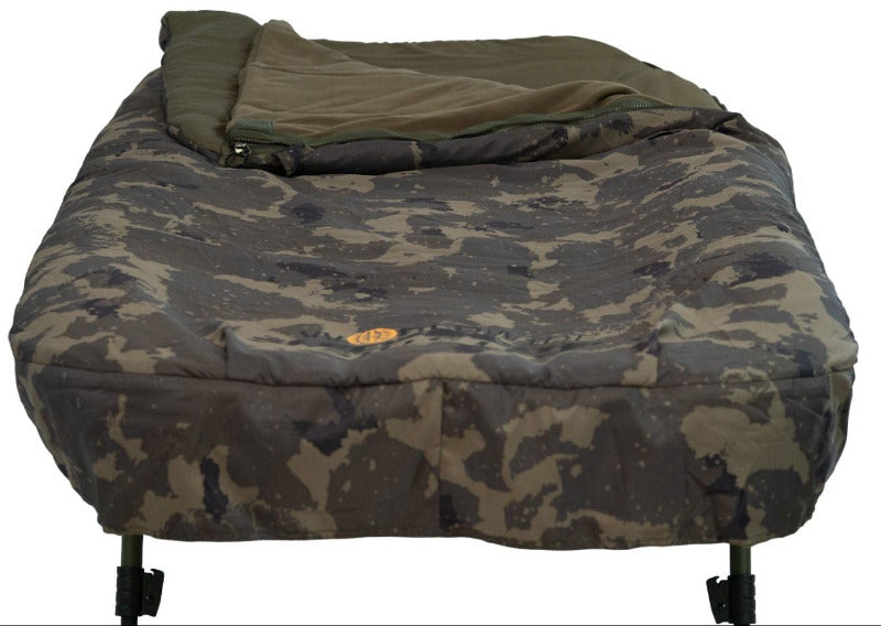 End-on view from the foot of the bed with the bag turned back, showing the Worldwide camo peach skin mattress outer, the gold oval badge and the leg tops.